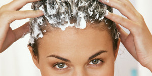 Frau massiert sich Shampoo in die Haare