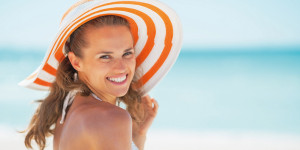 Frau mit Sonnenhut am Strand